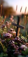 Wooden cross surrounded by flowers in a serene sunset setting photo