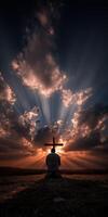 Man praying at sunset with a cross silhouetted against clouds photo