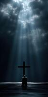 Person kneeling in prayer before a cross in dim light photo