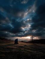 A man sits on the hill with a cross in the background photo