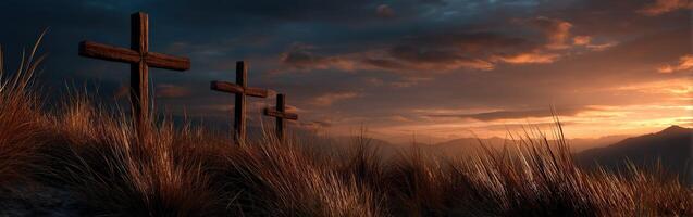 Three wooden crosses on a hill in front of a dramatic sunset photo