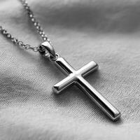 A silver cross necklace on a bed photo