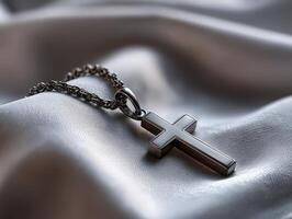 Beautiful metallic necklace with cross pendant on fabric photo