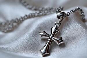 Silver cross pendant adorned on smooth satin fabric photo