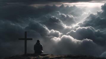 Man sitting on cross in the clouds photo