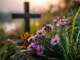 Vibrant flowers bloom near a cross at sunset photo