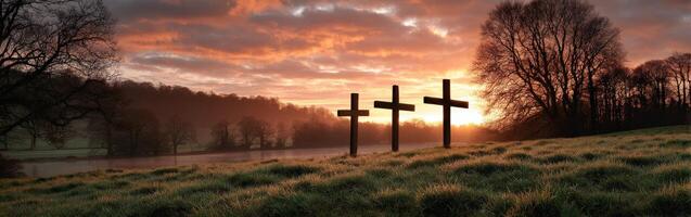Three crosses are on a hill in front of a river photo