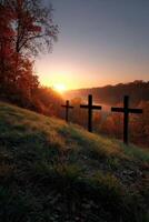 Sunrise over a serene cemetery with crosses and autumn foliage photo