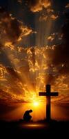 Sunrise reflection with cross silhouette and man in prayer photo