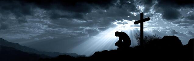 Silent prayer at sunset near a Christian cross photo