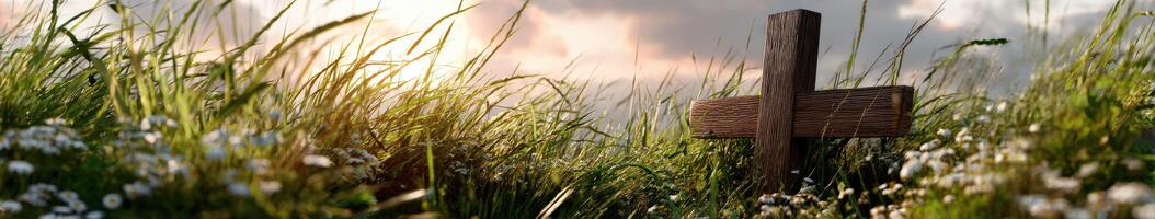 Wooden cross in a grassy field during sunset photo