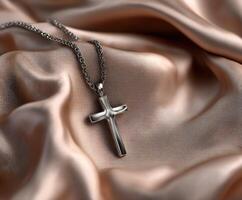 Silver cross pendant resting on elegant fabric surface photo