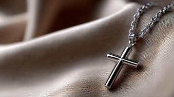A silver cross necklace on a beige background photo