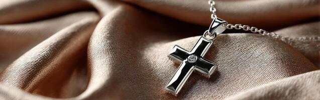 Silver cross pendant resting on silky fabric background photo