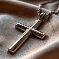 Minimalist silver cross pendant resting on soft fabric photo