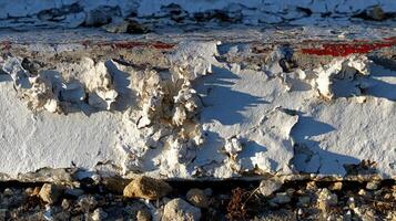 Texture of peeling paint on a weathered concrete surface photo