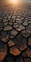 Cracked earth under sunset light in dry landscape photo
