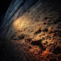 Light illuminating textured stone wall in urban setting photo