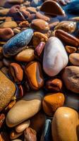 Colorful pebbles resting in clear water at the shore photo