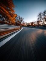 Curved road with vibrant autumn trees at dusk photo