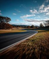 Curving racetrack surrounded by autumn foliage in sunlight photo