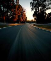 Racing along a winding road surrounded by trees at sunset photo