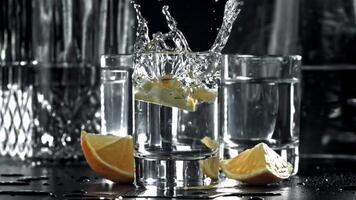 un rebanada de limón caídas dentro un vaso de vodka. filmado en un alta velocidad cámara a 1000 fps. alto calidad full HD imágenes video