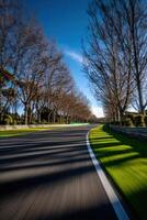 Curved road lined with trees under a blue sky photo
