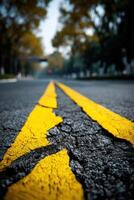 A yellow line on the road with a crack in it photo
