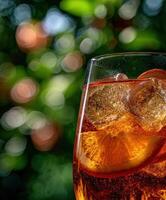 A glass of iced tea with a slice of orange photo