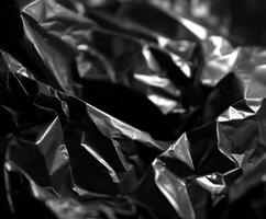 Textured black crumpled surface captures light details photo