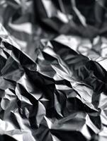 Crumpled aluminum foil with shiny texture and shadows photo