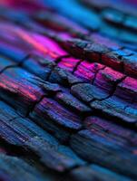 Charred wood texture illuminated with vibrant colors photo