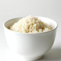 A white bowl filled with rice on a white background photo
