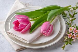 Festive table setting with pink tulips and linen napkin photo