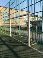 Broken goal net on a sunny day at a local soccer field photo