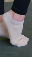lift your heels one by one do exercises for your feet gym environment visible, capturing stability, balance training in fitness video