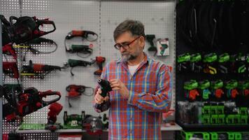 Senior Man Choosing Cordless Drill in Hardware Store video