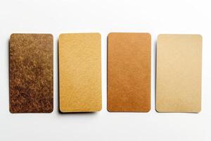 Four blank business cards are displayed on a clean white surface, showcasing a variety of textures and shades for customization photo