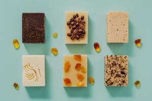 Six types of unique handcrafted soaps arranged aesthetically on a blue surface, featuring coffee beans and amber pieces as natural decor photo