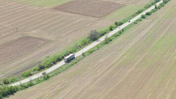 Aerial Cinematic Shot of Heavy Truck Moving Through Agricultural Valley Road Transport and Delivery Concept in Bulgarian Countryside video
