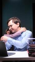 vertical Businessman father hugging daughter while working from home at night video