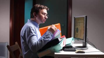 Office worker struggling with excessive paperwork at computer desk video