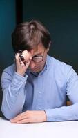 vertical Man contemplating with rosary beads at desk video