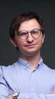 vertical close-up Confident businessman smiling with crossed arms in office setting video