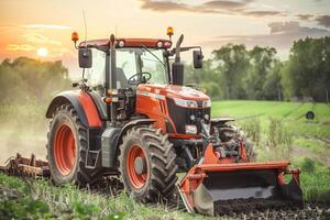 Modern red tractor plowing fertile green field at sunset photo