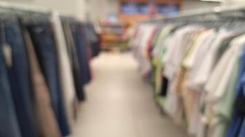 Blurred view of clothing aisle in store with various apparel on racks photo