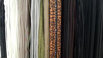A variety of textile shoe laces in different colors and patterns, hanging in a row photo