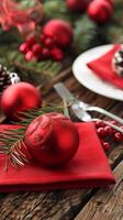 Festive christmas table setting with red ornaments and evergreen accents photo