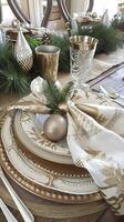 Elegant holiday table setting with gold and green accents photo